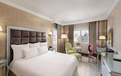 spacious king room with TV, desk, chair, and couch at Hilton Alexandria Corniche.