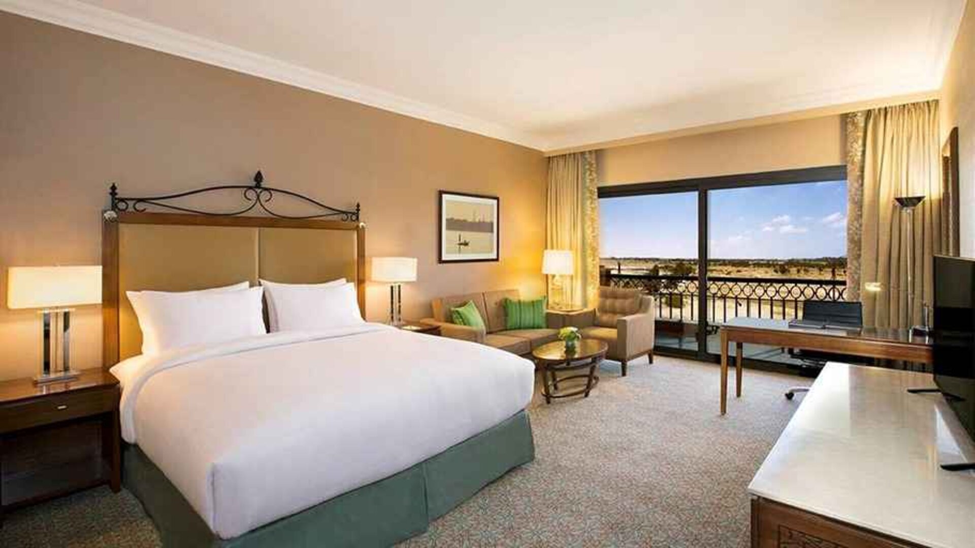 spacious delux king bedroom with TV, desk, chair, and lounge area at Hilton Alexandria King's Ranch.