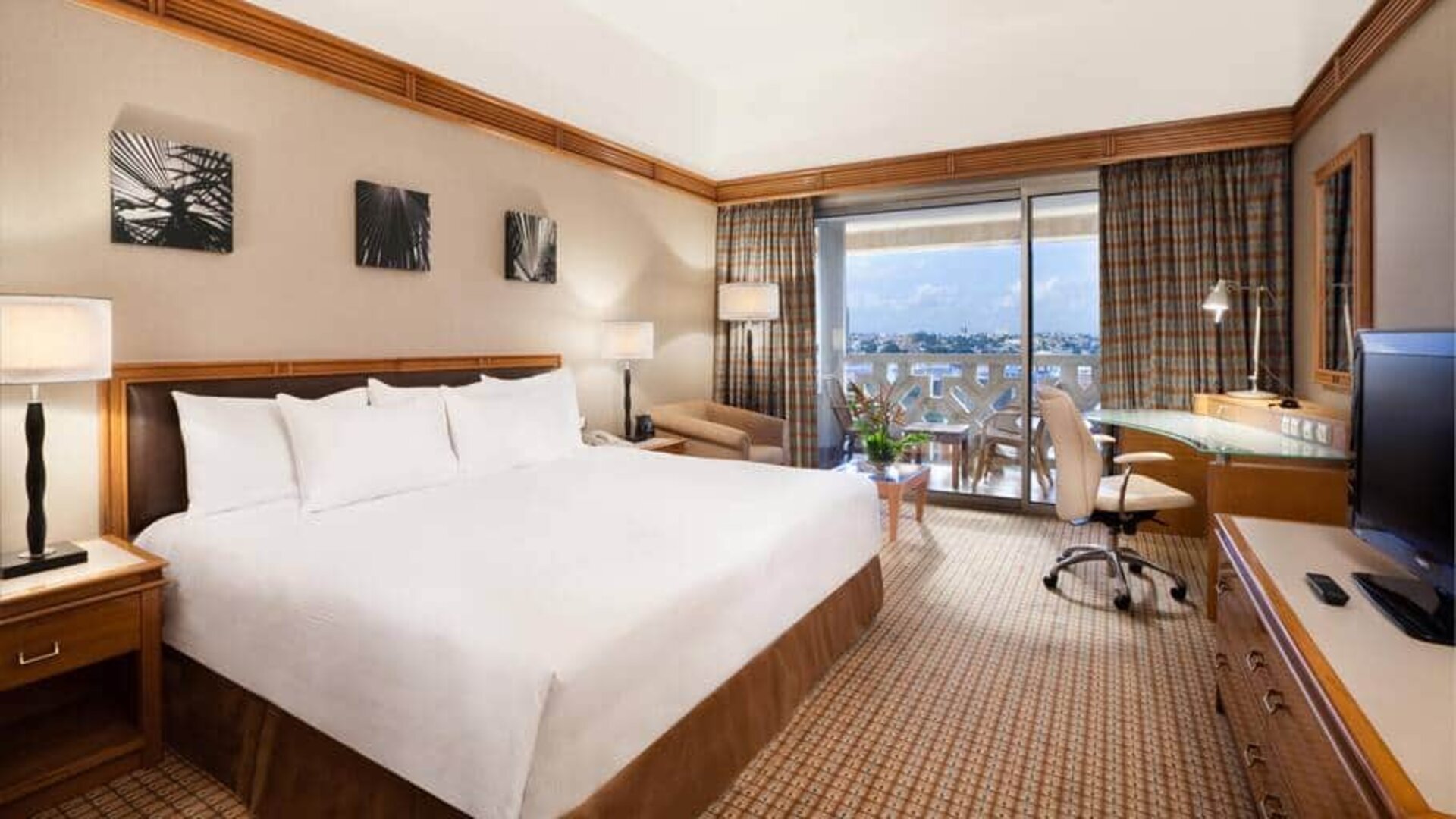 King suite with 1 king bed, desk,chair, tv and city view at the Hilton Yaounde.