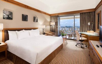 King suite with 1 king bed, desk,chair, tv and city view at the Hilton Yaounde.