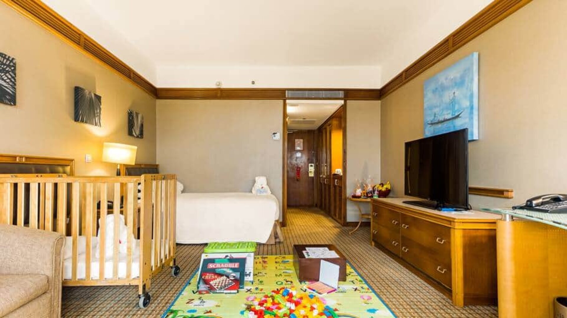 Spacious interconnecting room with twin bed, chair, desk and tv.