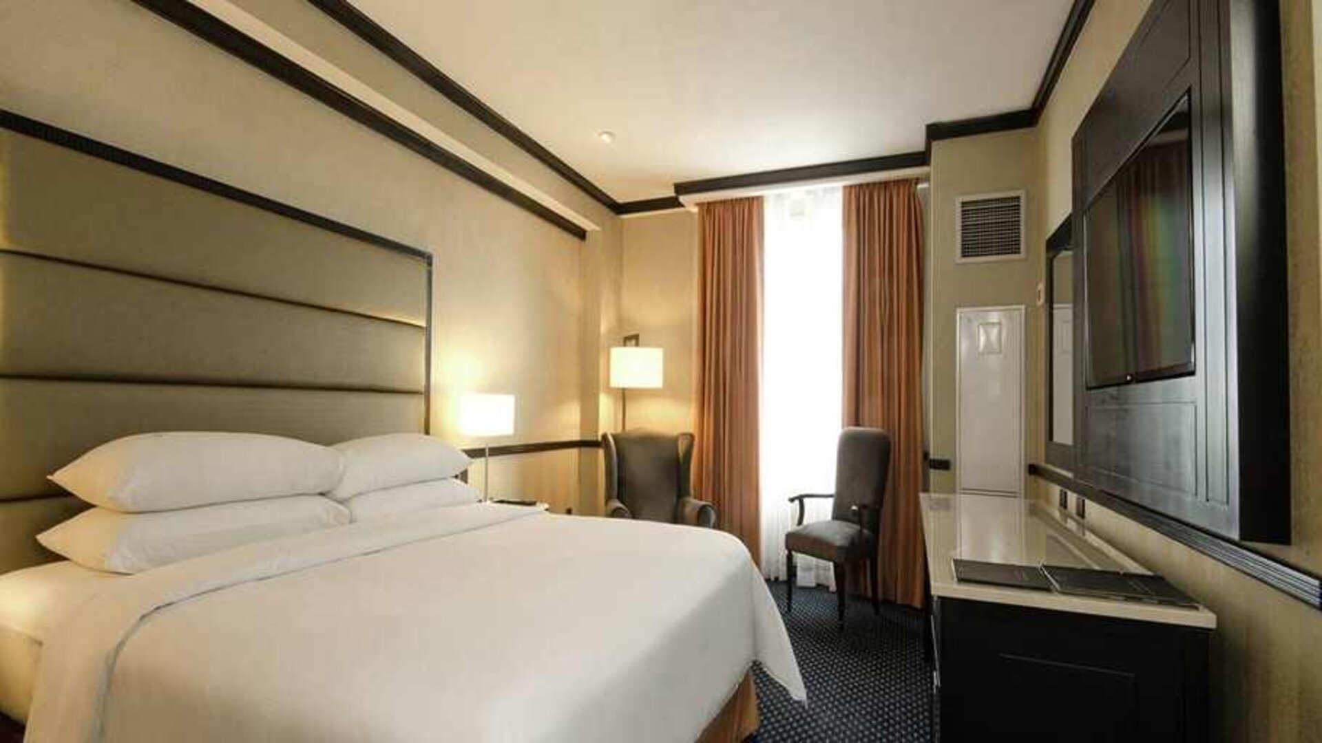 comfortable delux king room with TV and couches at Hilton Princess San Pedro Sula.