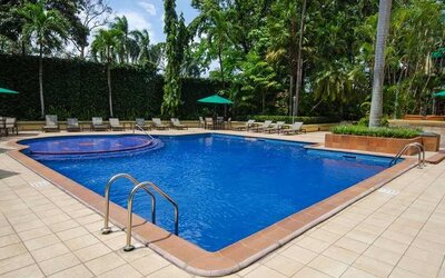 lovely outdoor pool with seating area and sun beds at Hilton Princess San Pedro Sula.