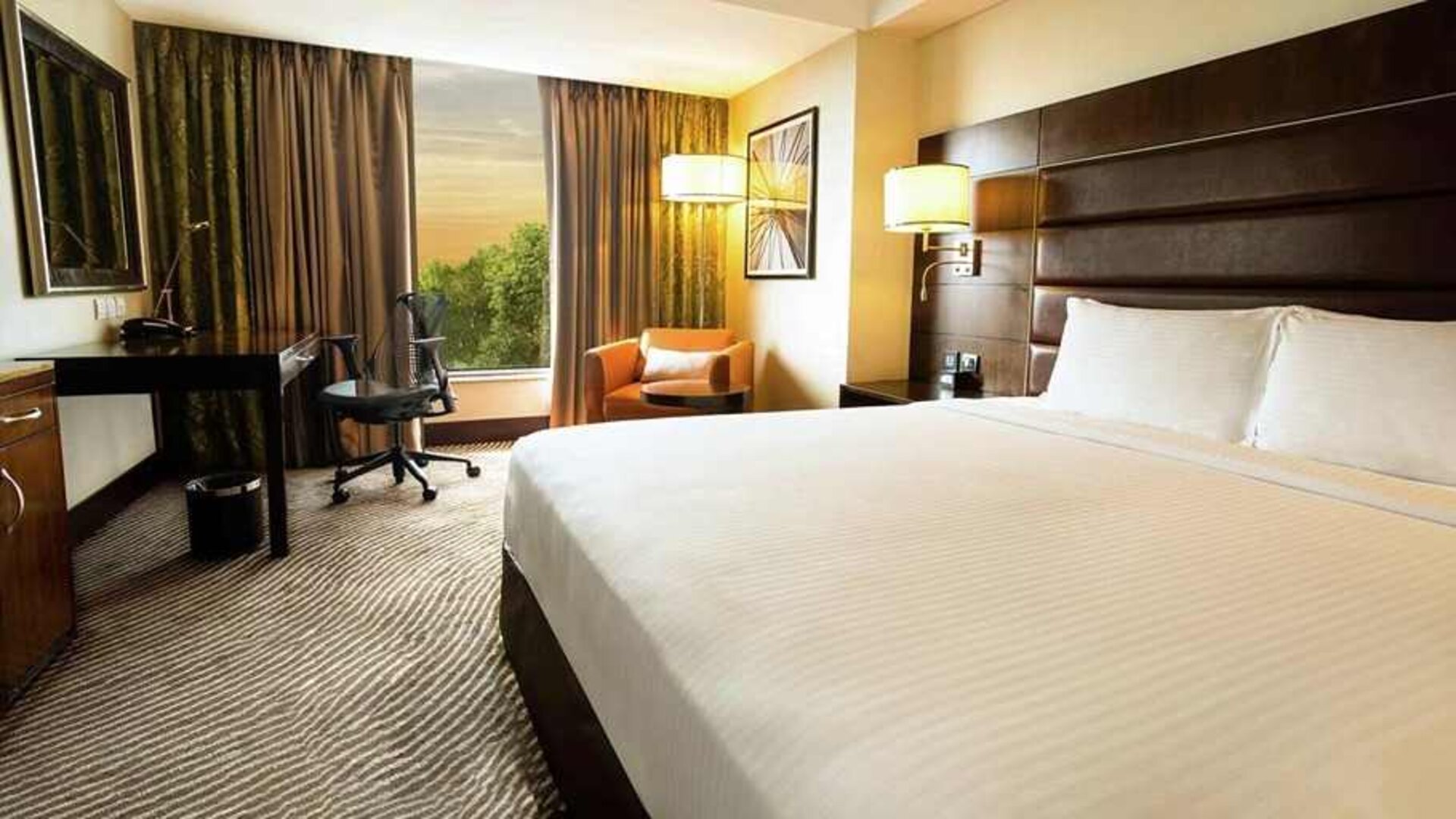 comfortable delux king with TV, business desk, and couch at Hilton Garden Inn Trivandrum.