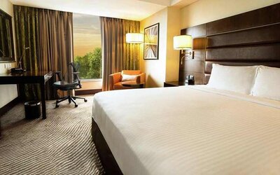 comfortable delux king with TV, business desk, and couch at Hilton Garden Inn Trivandrum.