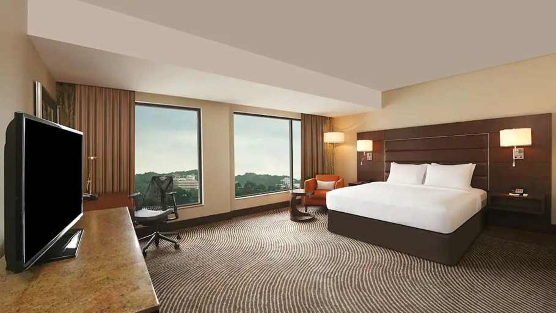 spacious king suite with TV, business desk, and couch at Hilton Garden Inn Trivandrum.