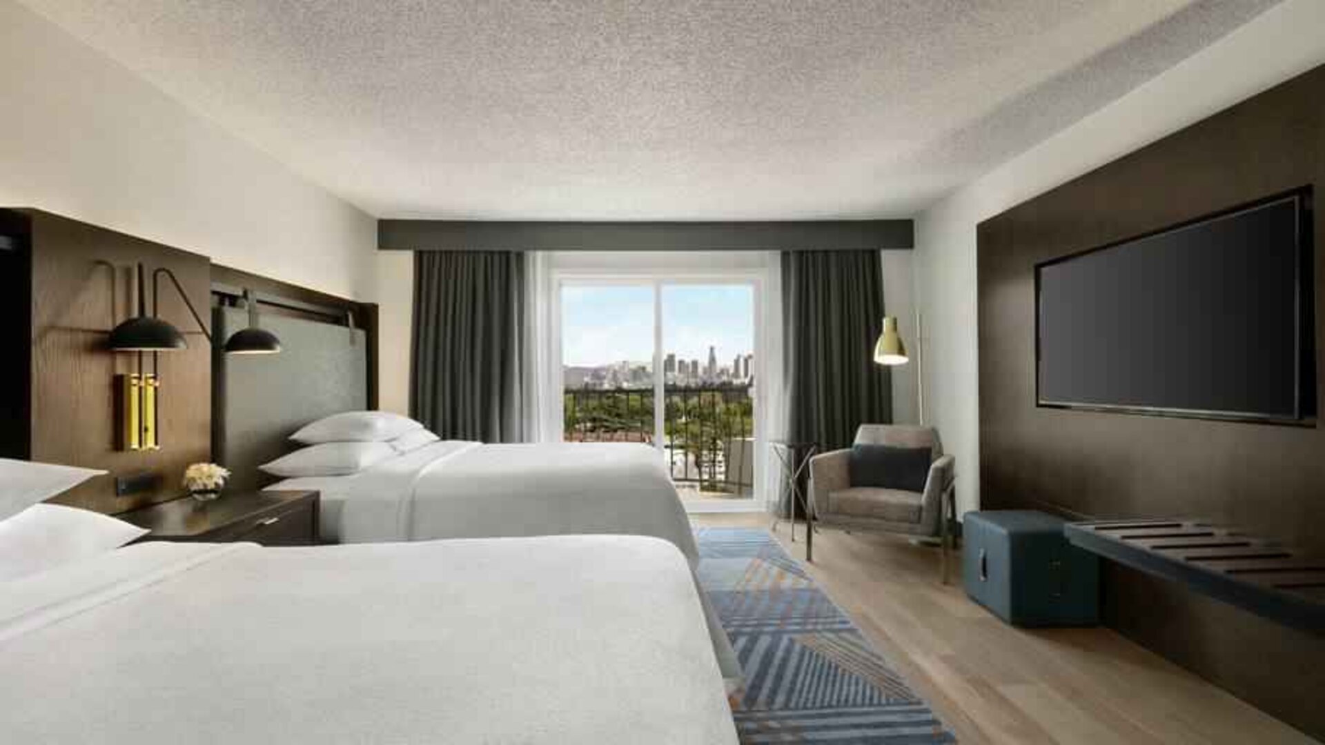 Double queen room with TV screen at the Embassy Suites by Hilton Los Angeles Downey.