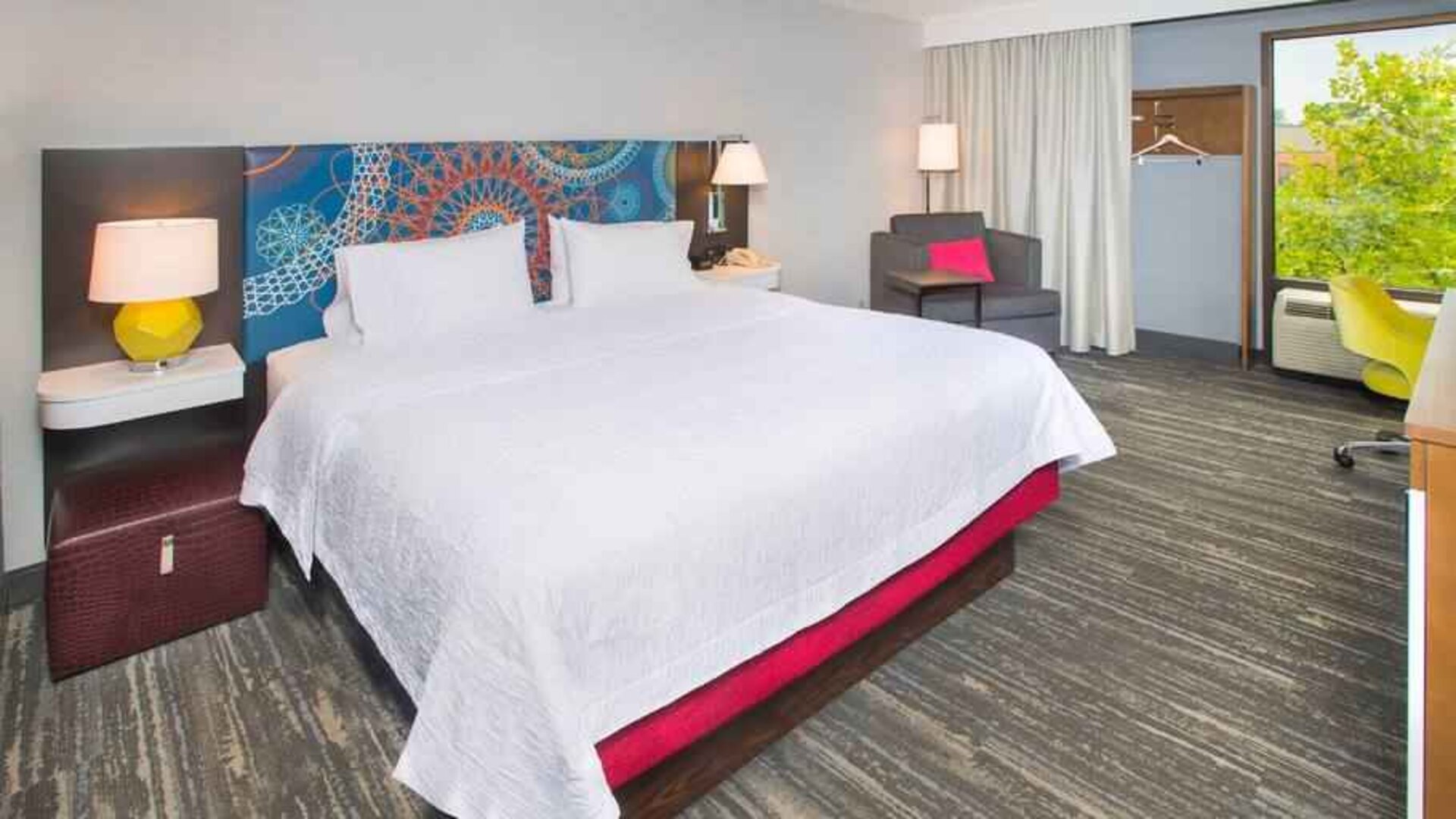 colorful king bedroom with natural light and work desk ideal for working remotely at Hampton Inn & Suites Annapolis.