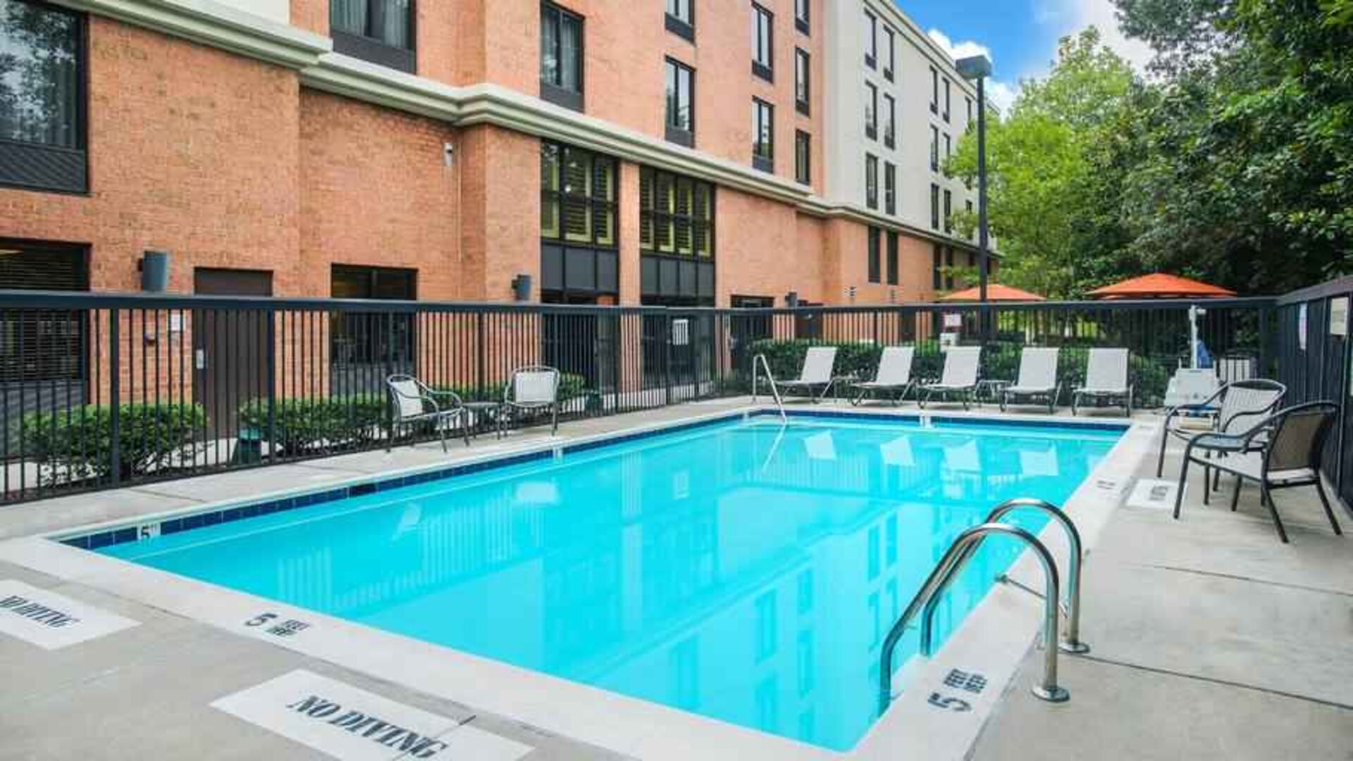 large outdoor pool with sunbeds and outdoor seating at Hampton Inn & Suites Annapolis.