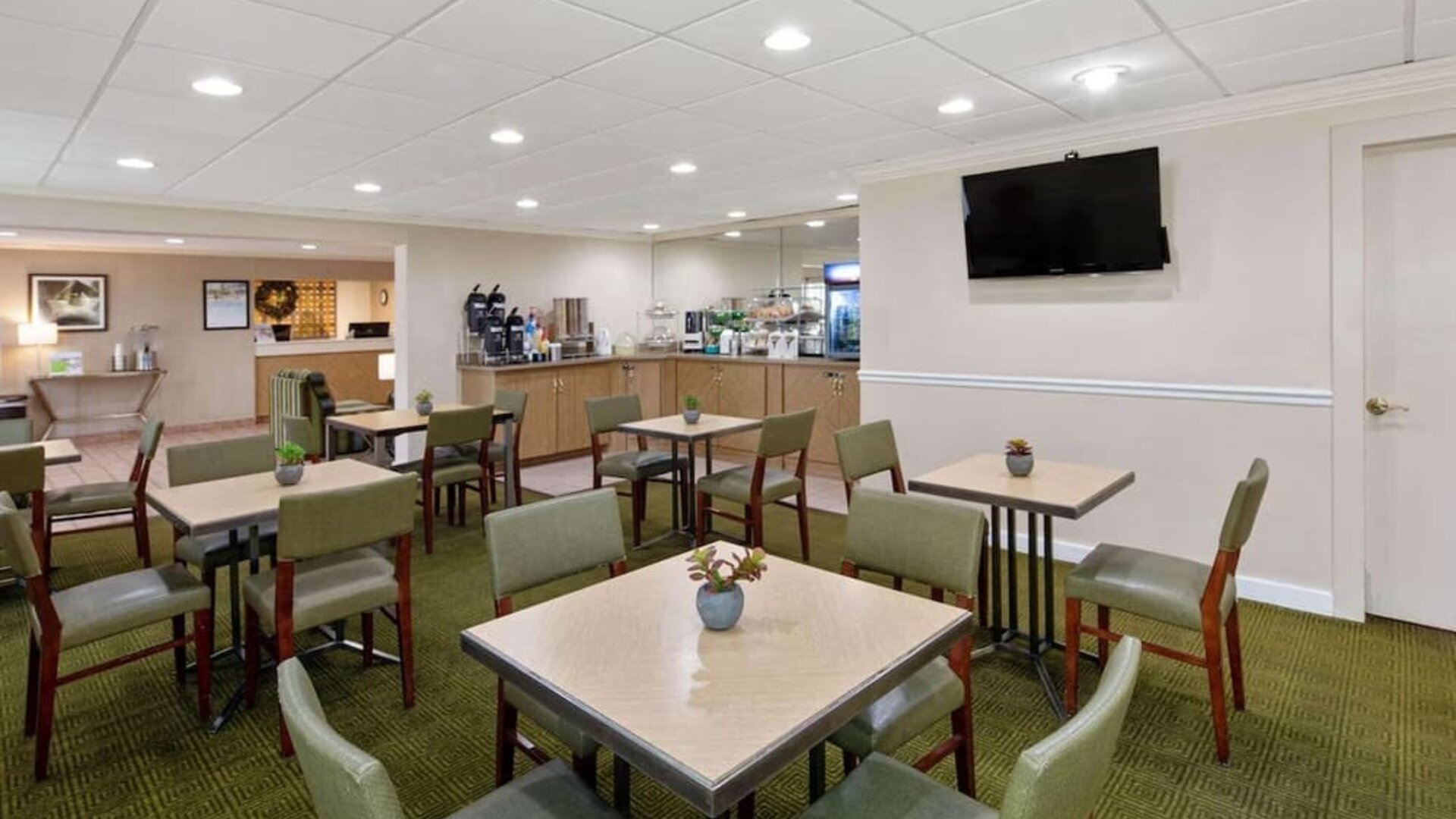 Bright breakfast and dining area with comfortable seating, offering guests a welcoming space to enjoy complimentary breakfast and refreshments at La Quinta Inn & Suites By Wyndham Sawgrass Mills.