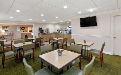 Bright breakfast and dining area with comfortable seating, offering guests a welcoming space to enjoy complimentary breakfast and refreshments at La Quinta Inn & Suites By Wyndham Sawgrass Mills.