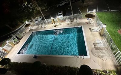 Outdoor swimming pool surrounded by lounge seating, offering guests a relaxing place to unwind and enjoy Florida's warm weather at La Quinta Inn & Suites By Wyndham Sawgrass Mills.