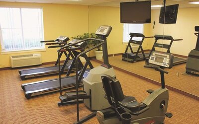 Fitness room with a selection of cardio equipment and workout facilities designed to support guests' health and wellness needs during their stay.