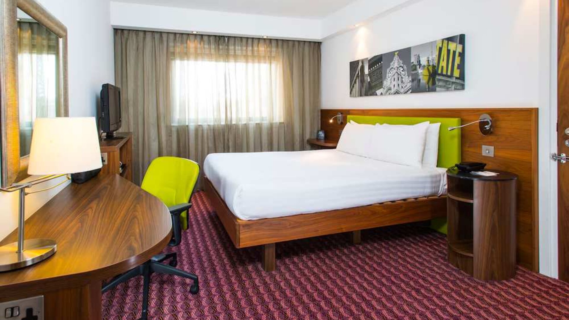 Spacious king room with king bed, natural light, and work desk and chair. 