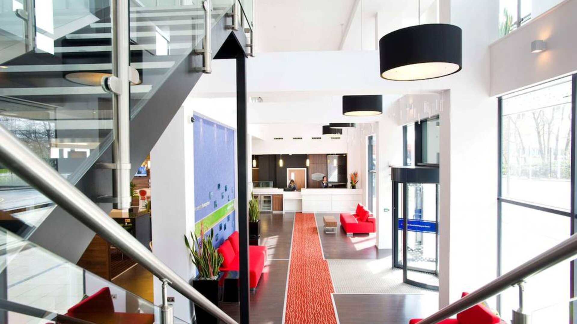 Staircase with natural light leading to reception desk. 