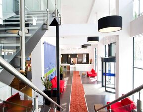 Staircase with natural light leading to reception desk. 