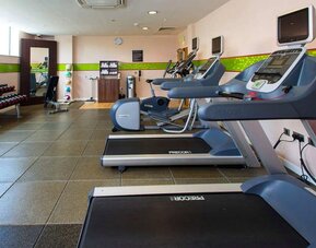 Fitness center well equipped with treadmills and step machines. 