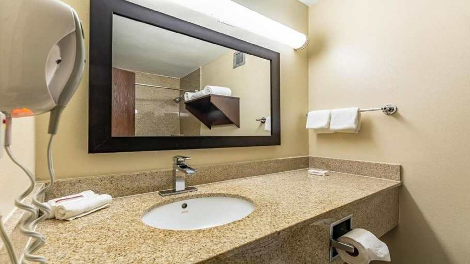 Clean and spacious guest bathroom at Red Roof PLUS+ & Suites Houston - IAH Airport SW.