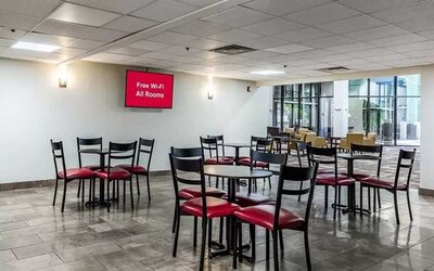 Open-plan dining and coworking space at Red Roof PLUS+ & Suites Houston - IAH Airport SW.