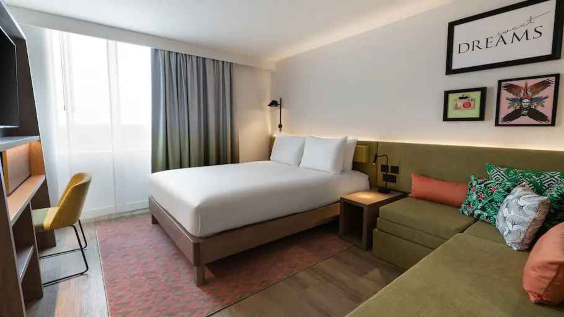 Queen bedroom with corner sofa at the Hampton by Hilton Istanbul Arnavutkoy.
