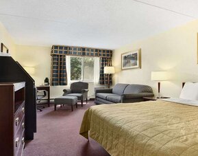 King bedroom with TV screen and workstation at Travelodge Ottawa East.