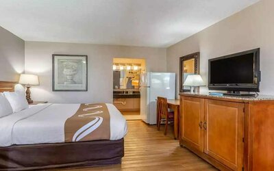 Spacious delux king room with TV, business desk, and fridge at Quality Inn Pasadena.