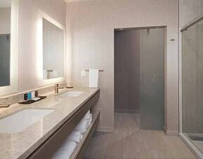 Guest bathroom with shower at H Hotel Los Angeles, Curio Collection By Hilton.
