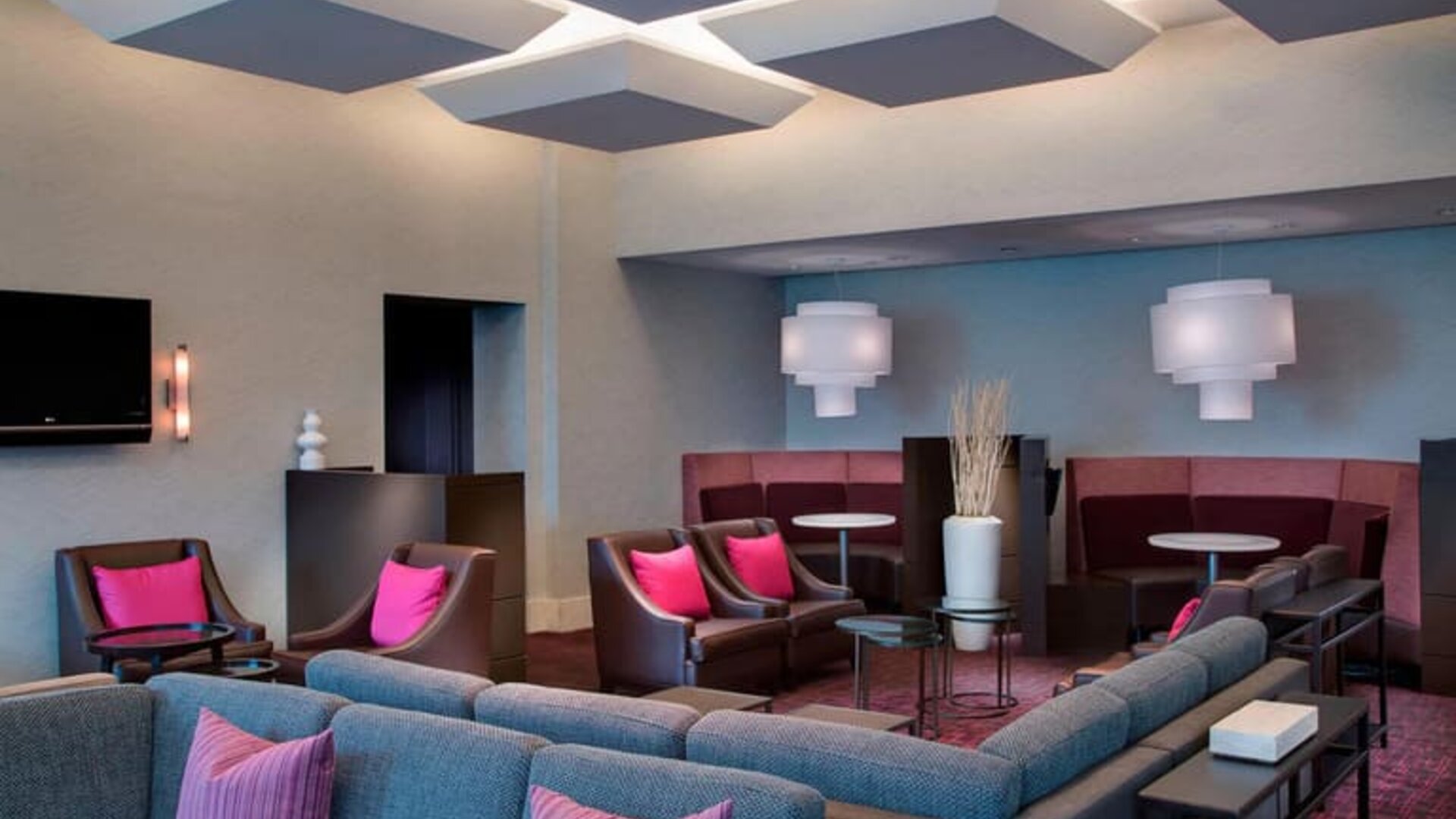 Comfortable couches in open-plan setting ideal for coworking at Courtyard By Marriott New York JFK Airport.