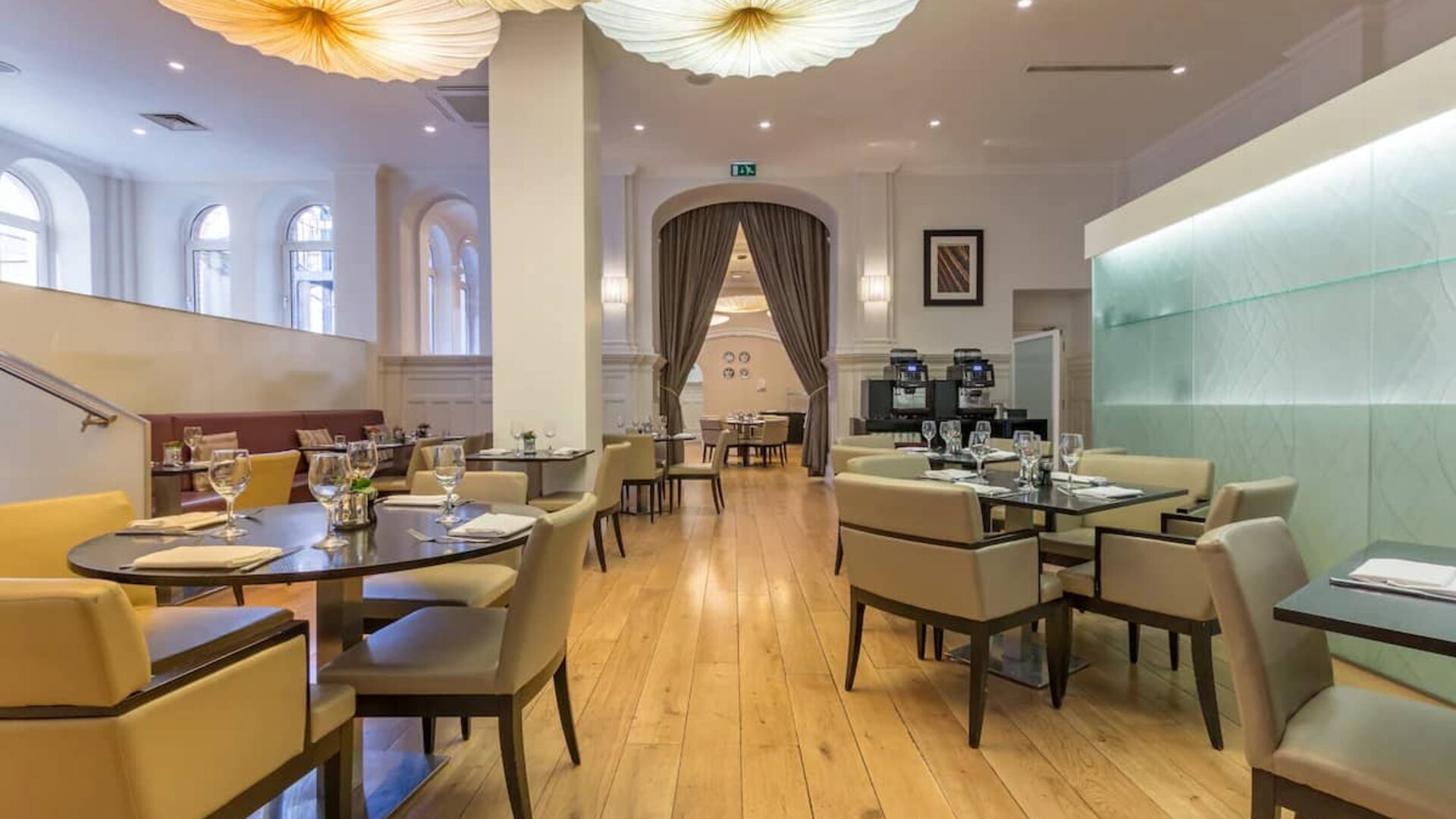 Tables and chairs in the airy, well-lit hotel restaurant.
