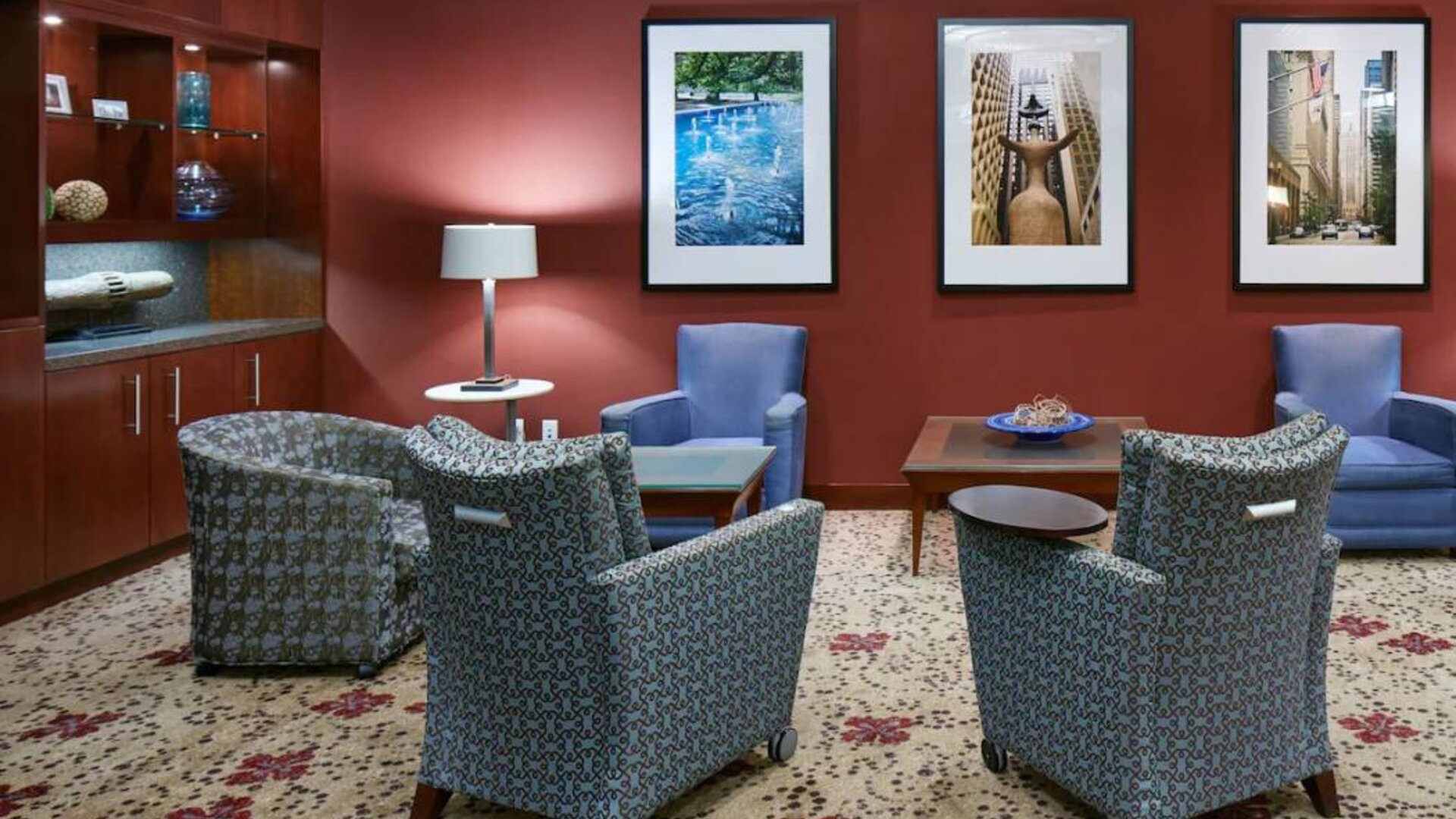 Hotel lounge, with armchairs and coffee tables, plus art on the wall.