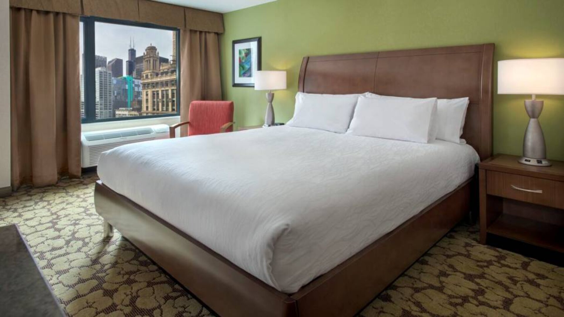 Double bed guest room within the Hilton Garden Inn Chicago Downtown Riverwalk, with city views through the large window.