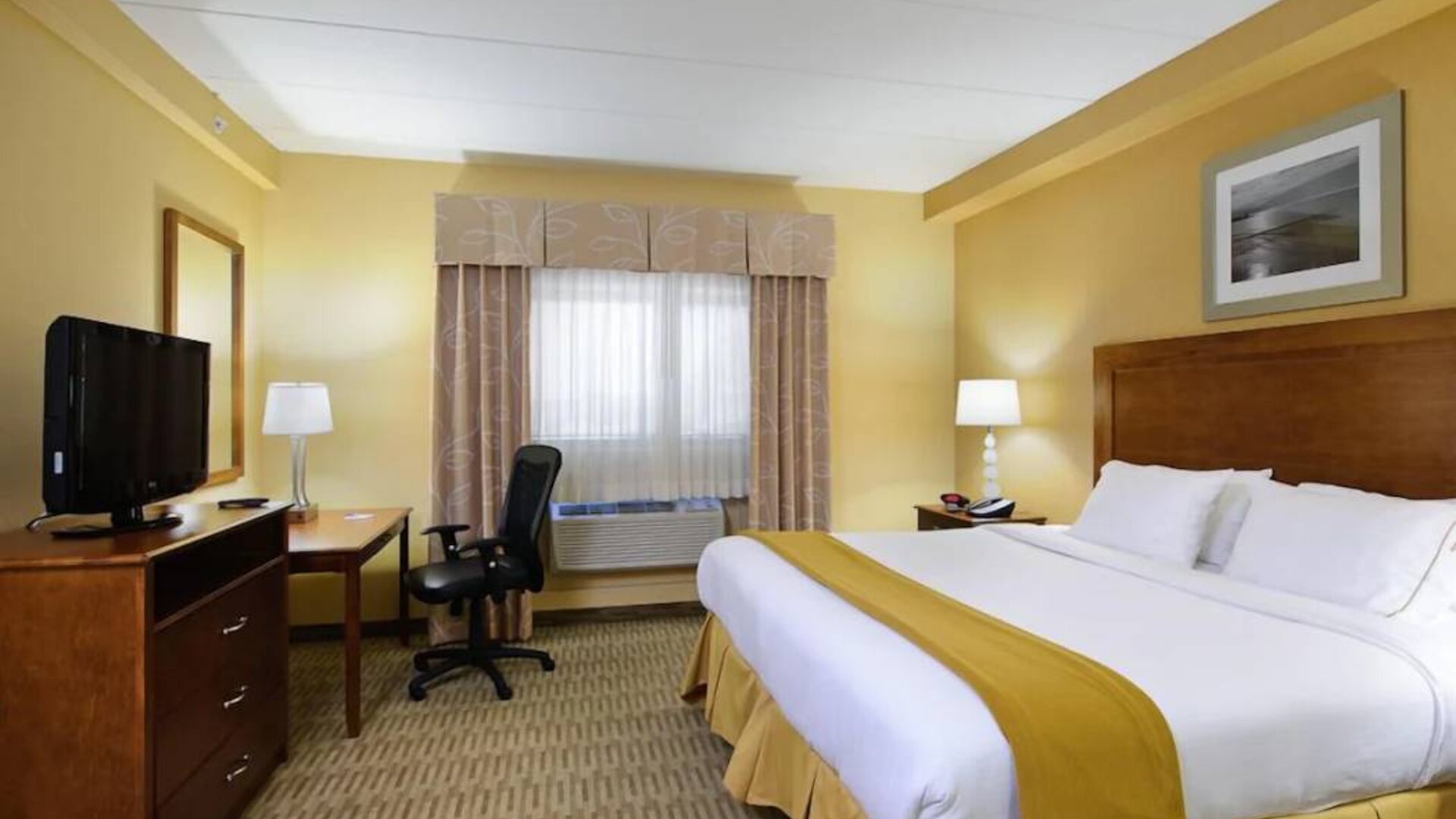 Double bed guest room in Holiday Inn Express Philadelphia Airport, with window and TV set.