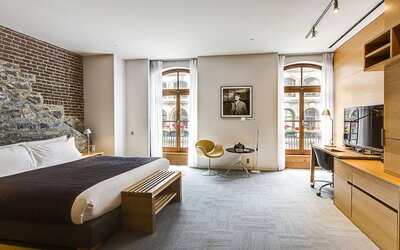 Double bed guest room in Hotel Gault, furnished with workspace desk and chair, plus large windows.