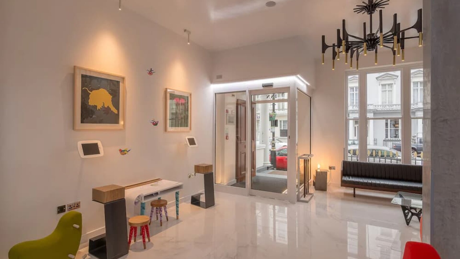 Entrance to the Victoria Inn, with a sleek white marble flooring, self-serve kiosks and chic furniture, fixtures.