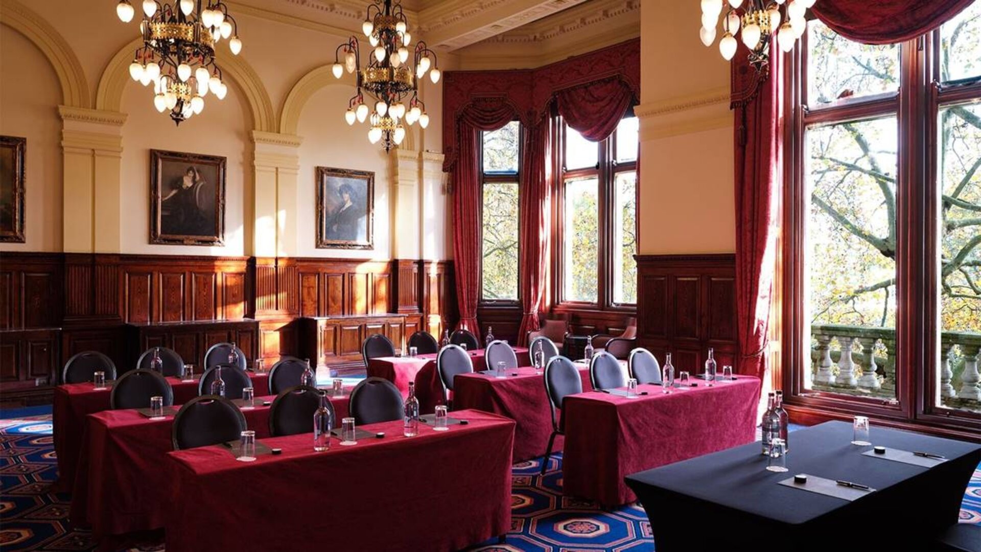 The River Room of The Royal Horseguards Hotel, a meeting space decorated with wood panels and chandeliers.