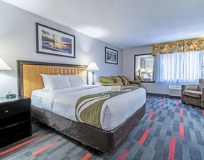 Guest room in Quality Inn Halifax Airport, with sofa, chair, and large window.