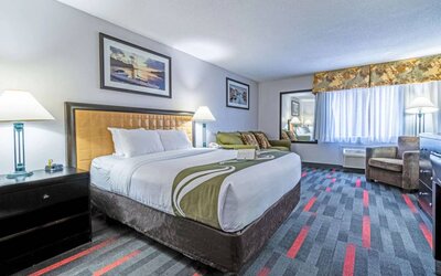 Guest room in Quality Inn Halifax Airport, with sofa, chair, and large window.