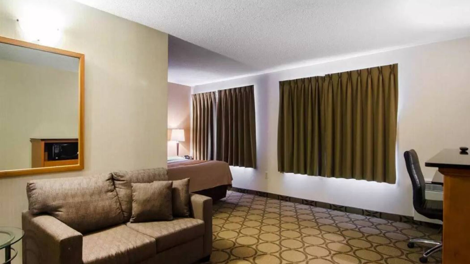 Guest room in the Comfort Inn Saskatoon, with double bed and sofa.