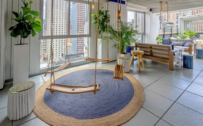 The Hilton Fashion District’s whimsical Sandbar Rooftop bar, including city views and swing seats.