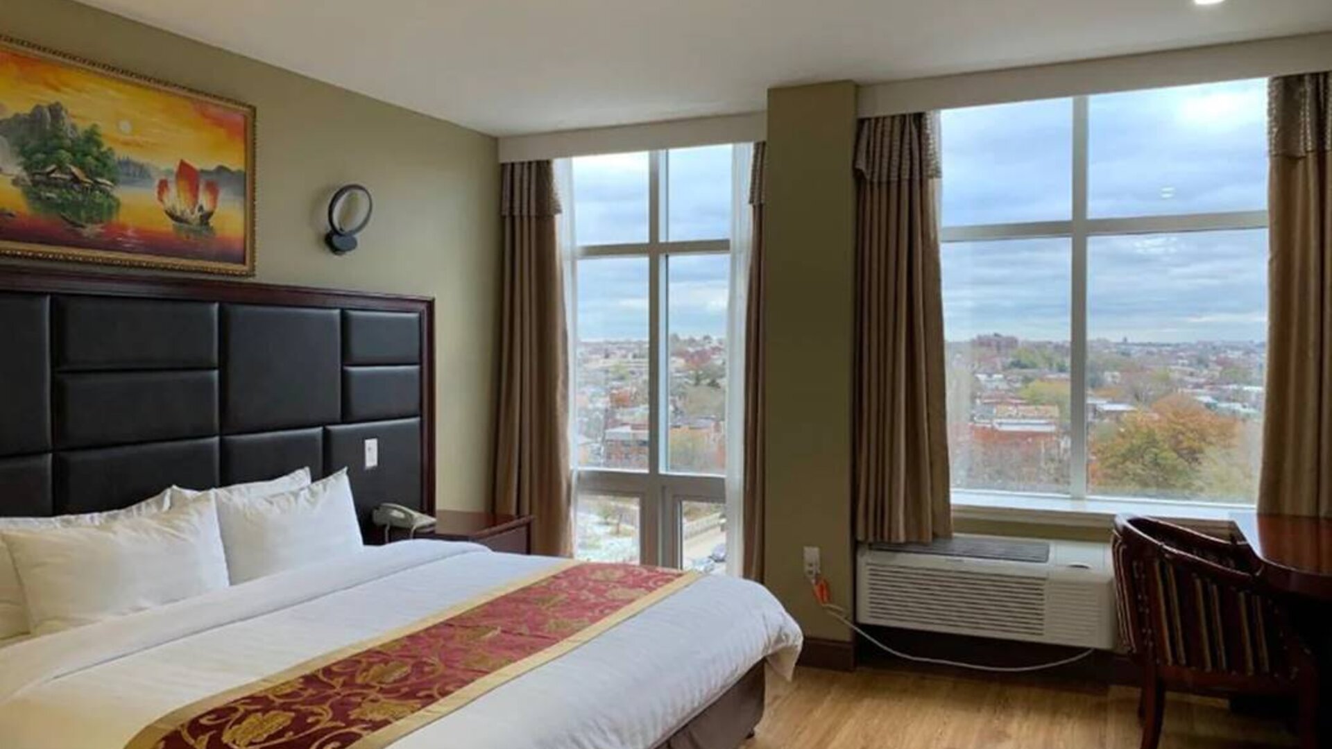 Guest room at the Queens Hotel, with double bed and large windows.