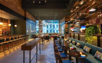 Moxy NYC Downtown’s Recreation restaurant, which has small tables and bar stool seating.