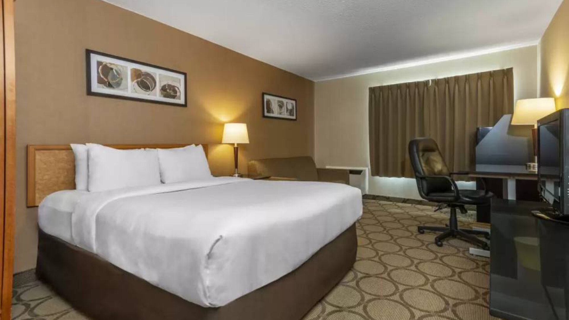 Guest room in Comfort Inn Brandon with double bed and workspace desk and chair.