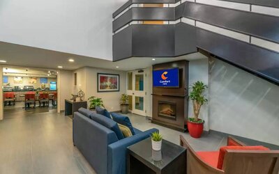 Lounge in the Comfort Inn Winnipeg Airport lobby, with comfy seating and cozy fireplace.
