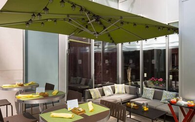 The hotel’s outdoor patio seating area, with mix of tables and chairs, and sofa seating.