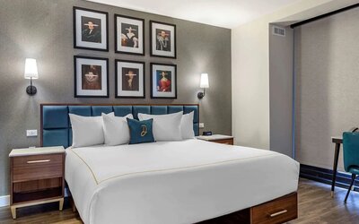 Double bed guest room in The Draper, Ascend Hotel Collection, with art on the wall above the bed, and bedside tables.