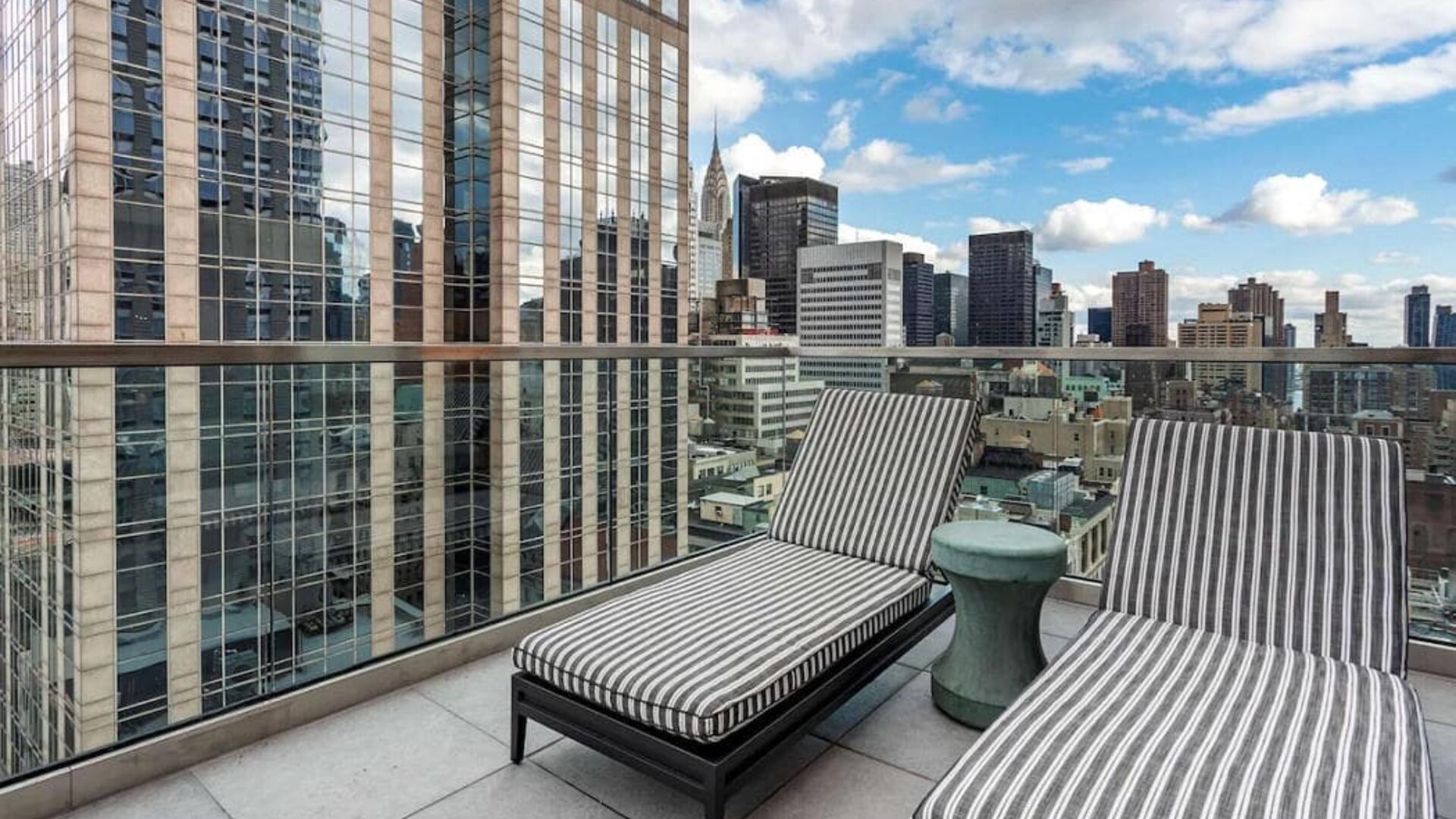 Panoramic city views from a guest room balcony in The Draper, Ascend Hotel Collection, with a pair of loungers.