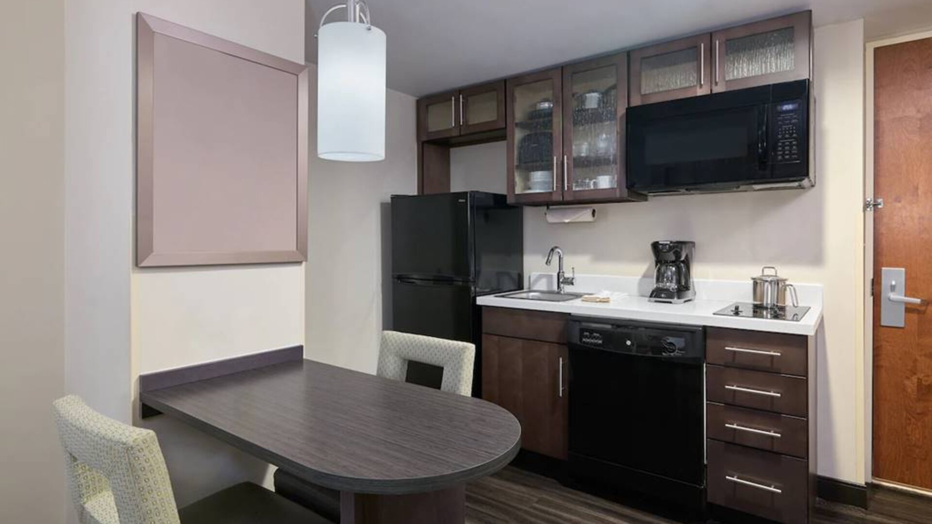 The kitchenette area in a guest room of Candlewood Suites Times Square, including fridge, oven, and microwave.