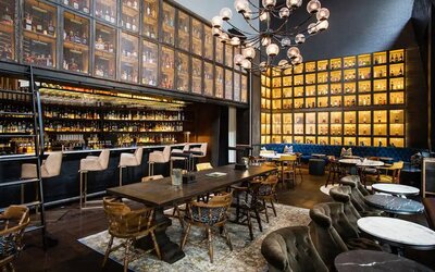 The bar and lounge of Hyatt Union Square New York, with hard floor, bar stools, and range of table sizes.