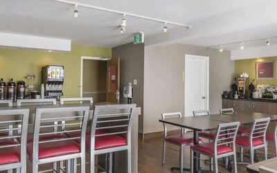 The hotel breakfast area has tall and standard chairs, and a wide range of breakfast fare.