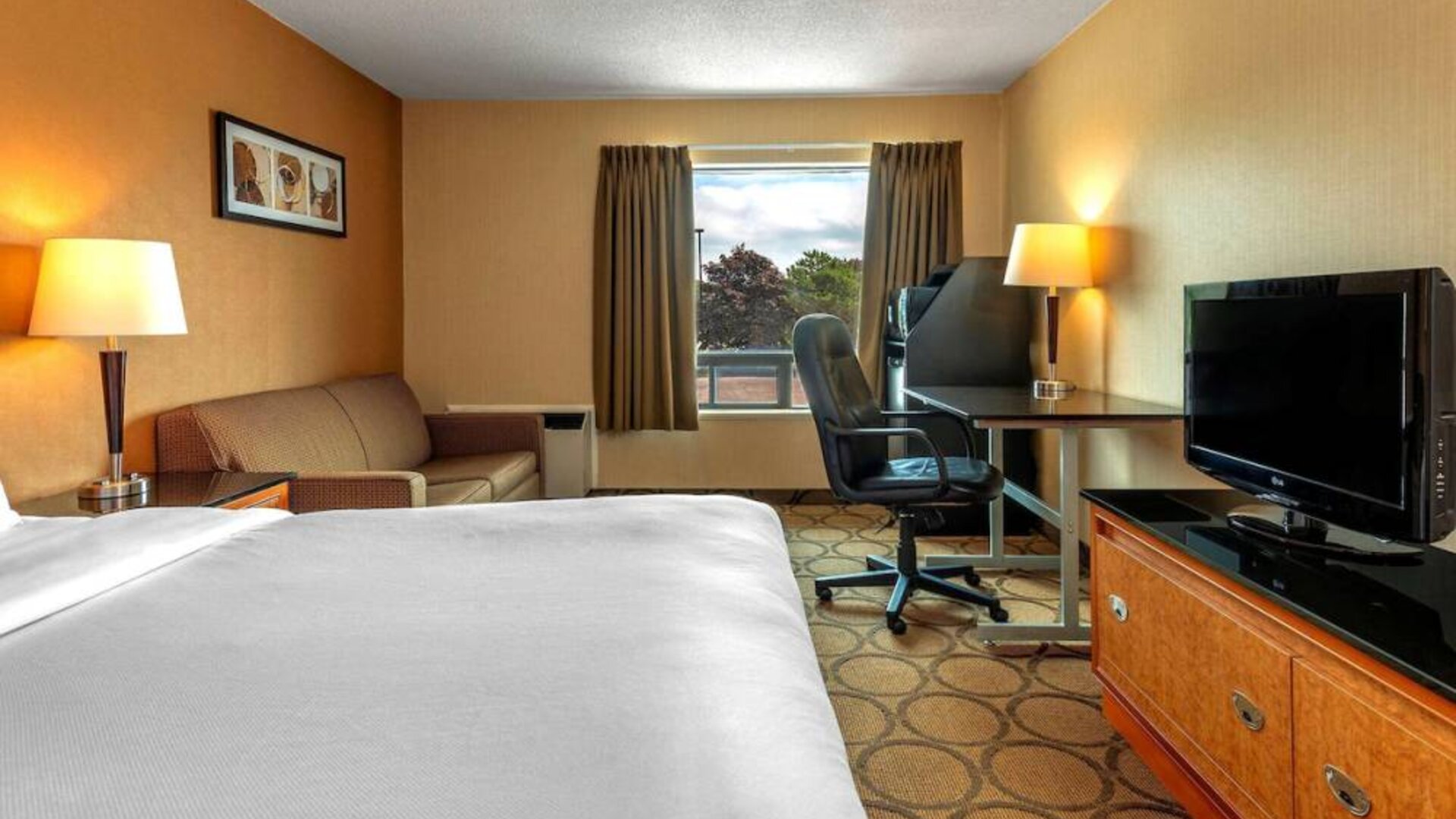 Double bed guest room in Comfort Inn Sault Ste. Marie, including a workspace desk and chair.